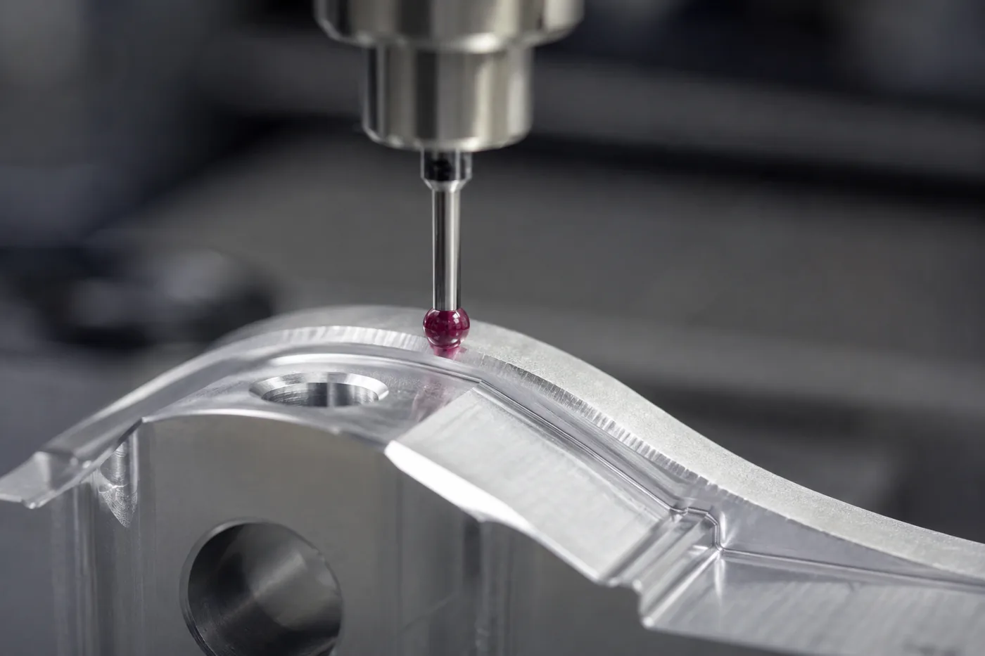 Messtaster prüft die Freiformfläche eines gefrästen Aluminium-Bauteils